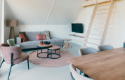 Moderne woonkamer van Big Lodge bij Holiday park De Boshoek, Nederland, met loft en gezellige inrichting.