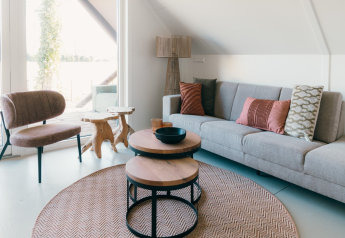 Moderne stue i Big lodge ved Holiday park De Boshoek i Holland, med lyse nuancer og elegante møbler.