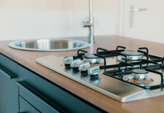 Moderne gaskookplaat en spoelbak in de keuken van de Big Lodge bij Holiday park De Boshoek, Nederland.