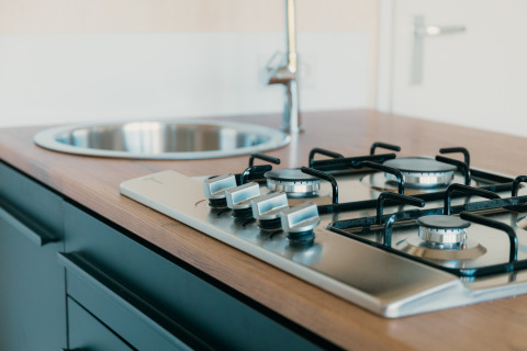 Moderne gaskookplaat en spoelbak in de keuken van de Big Lodge bij Holiday park De Boshoek, Nederland.