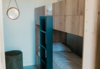 Interior del Big Lodge con literas y diseño moderno en Holiday park De Boshoek, Países Bajos.