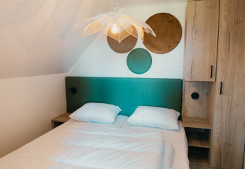 Chambre au Big lodge du Holiday park De Boshoek, Pays-Bas, avec une tête de lit verte et décor contemporain.
