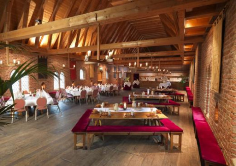 Großer Speisesaal mit Holzbalkendecke und Backsteinwänden im Expedition Archeon, Südholland, Niederlande.