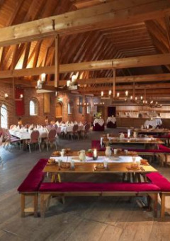 Amplio comedor con vigas de madera y paredes de ladrillo en Expedition Archeon, Holanda Meridional, Países Bajos.