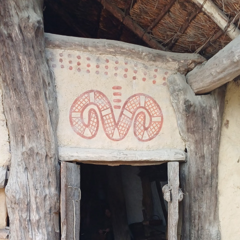 Decorazione tradizionale su porta con motivi rossi in casa di legno a Expedition Archeon, Olanda Meridionale.