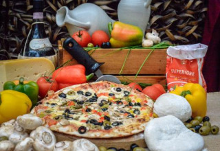 Lekkere pizza met verse groenten, kaas en wijn, als blikvanger van Expedition Archeon in Zuid-Holland.