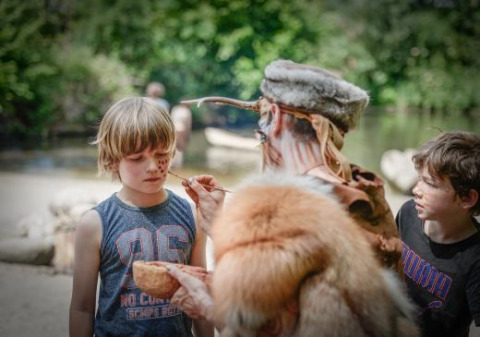 Una persona pinta la cara de un niño al aire libre cerca de Alphen aan den Rijn, Países Bajos, junto al río.
