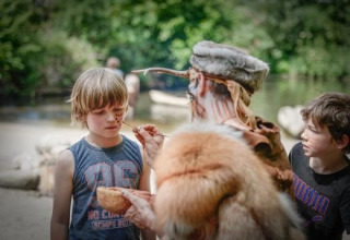 Una persona pinta la cara de un niño al aire libre cerca de Alphen aan den Rijn, Países Bajos, junto al río.