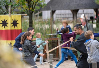 Bambini e adulti partecipano a una lezione di spada nell’Expedition Archeon, parco vacanze in Olanda Meridionale.