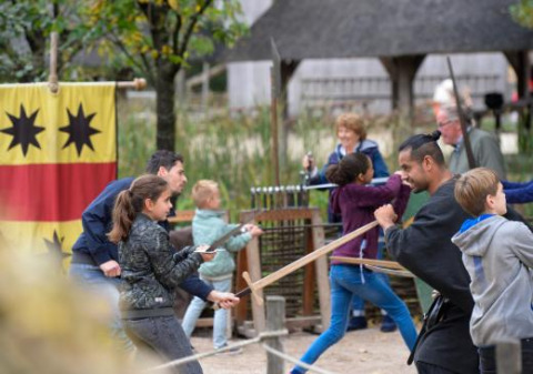 Bambini e adulti partecipano a una lezione di spada nell’Expedition Archeon, parco vacanze in Olanda Meridionale.