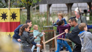 Niños y adultos participan en actividad de esgrima en Expedition Archeon, parque de vacaciones en Holanda del Sur.