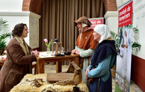 Personas vestidas con trajes históricos conversan en un puesto en Expedition Archeon, Holanda Meridional.
