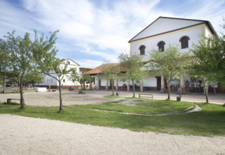 Vista del parque vacacional Expedition Archeon en Holanda Meridional, Países Bajos, con edificios blancos y árboles.