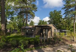 Foto esterna del lodge Loevestein Comfort al Veluwepark de Bosgraaf nei Paesi Bassi, tra alberi e natura.