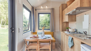 Lichte en moderne keuken met eethoek in Tiny Home Arrozal bij TAIGA Delta de l'Ebre, Spanje.