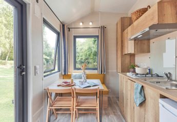 Lyst og moderne køkken og spiseplads i Tiny Home Arrozal ved TAIGA Delta de l'Ebre i Spanien.