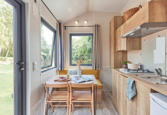 Lyst og moderne køkken og spiseplads i Tiny Home Arrozal ved TAIGA Delta de l'Ebre i Spanien.