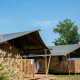 Safari-telte med sanitære faciliteter på Camping Tussen de Diepen i Holland under en klar blå himmel.