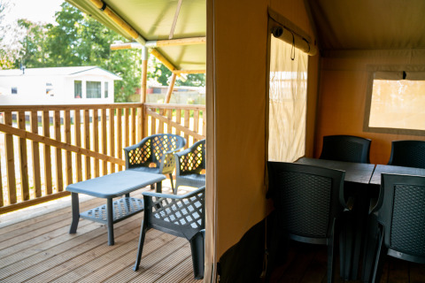 Espace intérieur et terrasse d’une tente safari avec chaises, Camping Tussen de Diepen aux Pays-Bas.