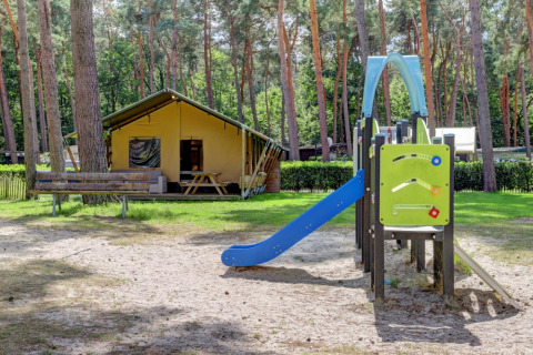 Safari-Zelt mit Sanitärbereich und Rutsche im Familiepark Goolderheide, Belgien, umgeben von Wald.