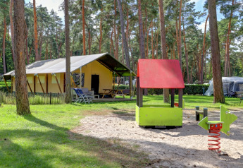 Safari-telt med privat sanitetsfaciliteter og legeplads med rutsjebane i Familiepark Goolderheide, Belgien.