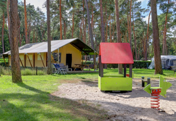 Safari-telt med privat sanitetsfaciliteter og legeplads med rutsjebane i Familiepark Goolderheide, Belgien.