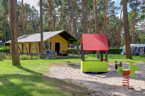 Safari-Zelt mit eigener Sanitäranlage und Spielplatz mit Rutsche im Familiepark Goolderheide, Belgien.