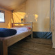 Innenansicht eines Safari-Zeltes mit Holzboden, Doppelbett und Etagenbett auf Camping Luna del Monte in Italien.