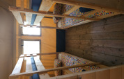 Four single beds in bunk style with colorful bedding inside a safari tent at Camping Luna del Monte, Italy.