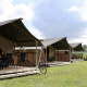Safaritenten met eigen sanitair en veranda op een grasveld, perfect voor comfortabel kamperen.