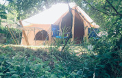 Tienda Castanha 4 Meter XL Bell Tent en Glamping de Cerveira, Portugal, rodeada de naturaleza y luz solar.