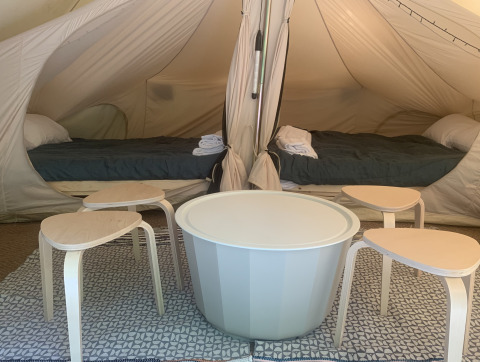 Indretningen af et Camelia XL Bell telt ved Glamping de Cerveira i Portugal, med to senge og moderne møbler.