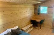 Het interieur van de Azalea Cabin bij Glamping de Cerveira in Portugal, met houten wanden en een tafel.