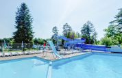 Udendørs swimmingpool med rutsjebane og liggestole ved Vestbirk Camping i Hovedstadsregionen, Danmark.