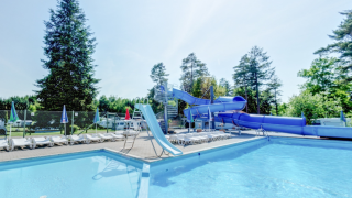 Udendørs swimmingpool med rutsjebane og liggestole ved Vestbirk Camping i Hovedstadsregionen, Danmark.
