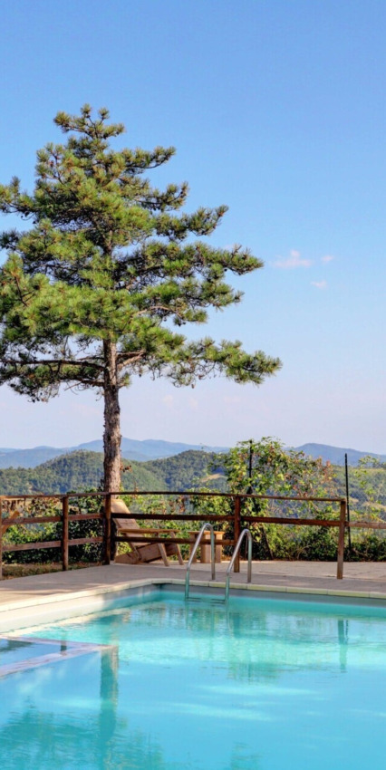 Piscina con vista su colline e alberi a Vestbirk Camping, regione della capitale della Danimarca, Danimarca.