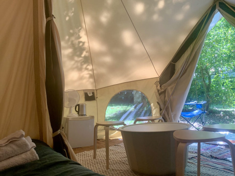 Binnenzicht van Laurelia XL Family Tent bij Glamping de Cerveira in Portugal met meubels en uitzicht op tuin.