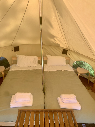 Innenansicht eines Safari-Zeltes mit zwei Betten, frischer Bettwäsche bei Glamping de Cerveira, Portugal.