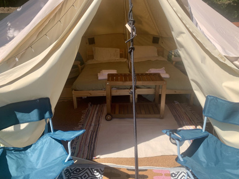 Interieur van de Carvalho 4M XL safaritent met bed en stoelen bij Glamping de Cerveira in Portugal.