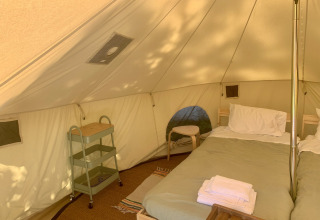 Interior de la tienda Carvalho 4 Meter XL Bell con cama doble y muebles en Glamping de Cerveira, Portugal.
