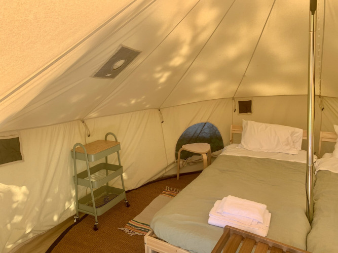 Innenraum eines Carvalho 4 Meter XL Bell Zeltes mit Bett und Möbeln bei Glamping de Cerveira in Portugal.