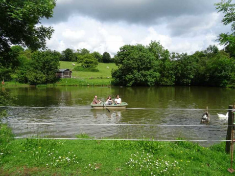 Familia remo en un bote en un lago tranquilo en Feather Down La Flocellière en Vendée, Pays de la Loire, Francia.