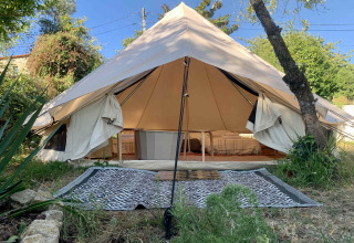 Grote safari-belltent met open voorkant en bedden bij Glamping de Cerveira, Portugal, in het groen.