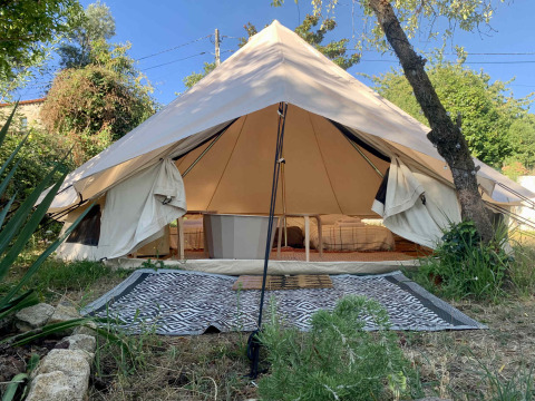 Grote safari-belltent met open voorkant en bedden bij Glamping de Cerveira, Portugal, in het groen.
