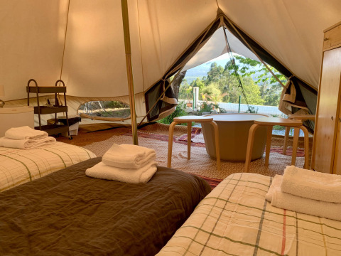 Interieur van de Oliveira Bell Standard Bell Tent bij Glamping de Cerveira in Portugal, met bedden en uitzicht.