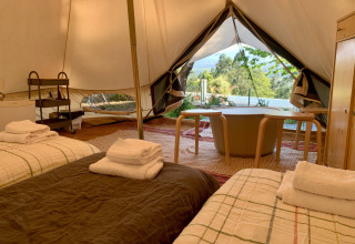 Interieur van de Oliveira Bell Standard Bell Tent bij Glamping de Cerveira in Portugal, met bedden en uitzicht.