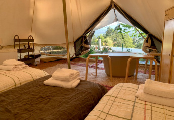 Interieur van de Oliveira Bell Standard Bell Tent bij Glamping de Cerveira in Portugal, met bedden en uitzicht.