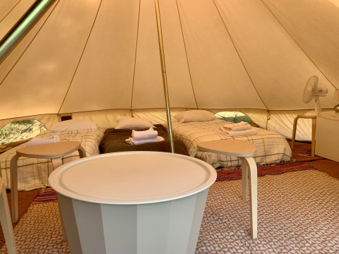 Innenansicht des Oliveira Bell Standard Bell Zeltes bei Glamping de Cerveira in Portugal mit Betten und Möbeln.