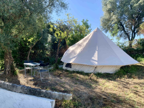 Groot glamping tent en buitentafel onder bomen bij Glamping de Cerveira vakantiepark in Noord-Portugal.