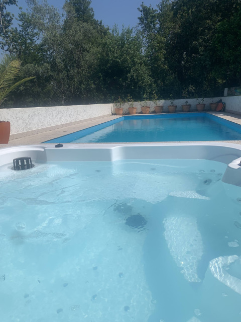 Jacuzzi climatizado en primer plano y piscina al aire libre de Glamping de Cerveira en el norte de Portugal.